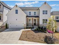 Charming two-story home with white siding, a two-car garage, and beautifully landscaped front yard at 117 Villanueva Rd, Woodstock, GA 30188