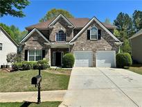 Charming two-story brick home with a well-manicured front lawn and a two-car garage, perfect for a Gathering at 1074 Frog Leap Nw Trl, Kennesaw, GA 30152