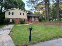Charming two-story home with a brick facade and a well-manicured front yard at 1247 Shoreham Dr, Atlanta, GA 30349