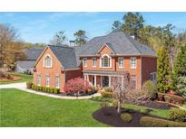Stately brick home with manicured lawn, mature trees, and a welcoming front porch creating an inviting curb appeal at 5124 Parkwood Oaks Ln, Smyrna, GA 30126