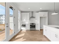 Bright kitchen features white cabinetry, stainless steel appliances, and hardwood flooring at 2340 Edgar Park Pl # 97, Duluth, GA 30096
