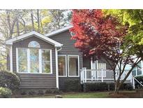 Charming home exterior featuring a well-manicured lawn, lovely landscaping, and a cozy front porch with white railings at 2362 Virginia Ne Pl, Atlanta, GA 30305