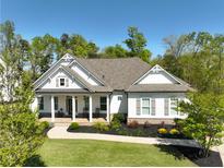 Beautiful single Gathering home with a manicured lawn and inviting front porch with traditional design elements at 305 Red Gate Ln, Canton, GA 30115