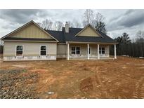 Charming home featuring a covered porch and classic architectural details in a neutral color palette at 476 Benson Meadows Dr, Dallas, GA 30157