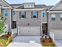 Beautiful townhouse with a two-car garage, gray brick, and charming curb appeal at 1347 Fern Ridge Ct # 29, Norcross, GA 30093