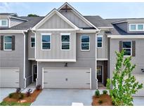 Stylish two-story townhome featuring a gray brick facade, attached garage, and inviting front entrance at 1357 Fern Ridge Ct # 30, Norcross, GA 30093