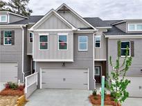 Charming townhome showcasing a modern design with painted brick and gray siding at 1377 Fern Ridge Ct # 32, Norcross, GA 30093