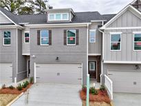 Charming townhome featuring a gray brick facade, attached garage, and well-maintained landscaping at 1387 Fern Ridge Ct # 33, Norcross, GA 30093
