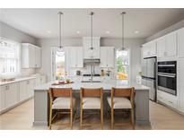 Bright kitchen features white cabinetry, quartz countertops, stainless steel appliances, and pendant lighting at 2625 Camphor Se Xing # 86, Smyrna, GA 30080