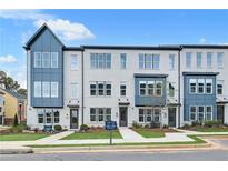 Modern townhouse featuring a gray brick facade, large windows, and well-manicured landscaping at 2637 Camphor Se Xing # 83, Smyrna, GA 30080