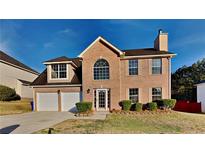 Charming two-story brick home with a two-car garage and manicured front yard at 6808 Foxfire Pl, South Fulton, GA 30349