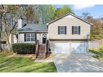 Charming split-level home features a well-manicured lawn, two-car garage, and inviting front porch at 2876 Davis Mill N Rd, Dallas, GA 30157