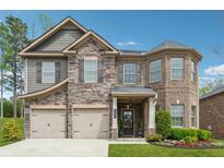 Charming two-story home featuring a stone and brick facade, a two-car garage, and a well-manicured lawn at 406 Dunaway Ct, Grayson, GA 30017