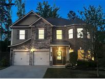 Charming two-story home featuring a stone facade, manicured lawn, and inviting front entrance at 406 Dunaway Ct, Grayson, GA 30017