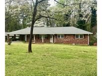 Charming brick home with a well-maintained front yard and mature trees offering shade and curb appeal at 2678 Oswood Dr, Tucker, GA 30084