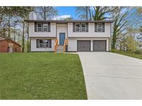 Charming two-story home with a manicured lawn and a long driveway leading to a two-car garage at 5331 Woodbin Dr, Norcross, GA 30093