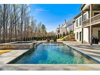 Backyard pool and spa with lush landscaping and comfortable seating area, perfect for relaxation and entertainment at 109 Owens Mill Pl, Canton, GA 30115
