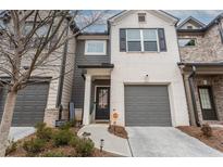 Charming two-story townhome with a well-maintained front yard, gray garage door, and a welcoming entrance at 3132 Meadowstone Sw Ln, Atlanta, GA 30331