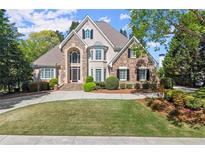 Beautiful two-story home featuring stone and stucco, well manicured landscaping, and a circular driveway at 2314 Edgemere Lake Cir, Marietta, GA 30062