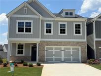 Beautiful two-story home featuring a brick and light gray facade, attached two car garage, and well-manicured lawn at 315 Lakeside Ct, Canton, GA 30114