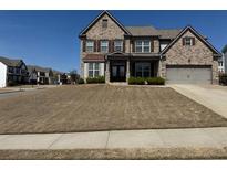 Charming two-story brick home with a well-maintained lawn and attached two-car garage at 5530 Lacebark Pine Ct, Cumming, GA 30040