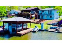 Stunning waterfront home featuring a private dock, boat house and jet ski lift for ultimate lakeside living at 8562 Lake Dr, Snellville, GA 30039