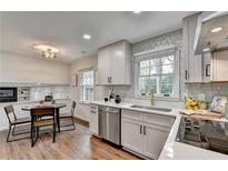 Well-lit kitchen featuring stainless steel appliances, white cabinets, and a cozy breakfast nook at 1450 Cedarhurst Dr, Dunwoody, GA 30338