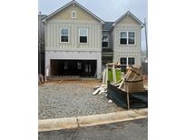 Under construction, this two-story home features large windows and a two-car garage awaiting completion at 329 Lakeside Court, Canton, GA 30114