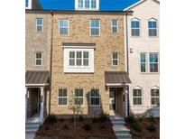 Charming townhome featuring a brick facade, covered entry, and multiple windows at 4589 Hawthorn Rose Ln, Buford, GA 30518