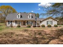 Charming home featuring a welcoming front porch,dormers, and a well-maintained lawn on a sunny day at 300 Smith Ave, Bowdon, GA 30108