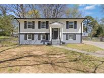 Charming two-story home featuring fresh paint, black shutters, and a welcoming front entrance at 6414 Bimini Dr, Forest Park, GA 30297