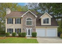 Charming two-story home featuring a stone facade, a two-car garage, and manicured front lawn at 164 Edison Dr, Stockbridge, GA 30281