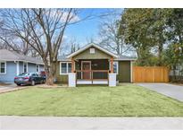 Charming bungalow featuring a well-manicured lawn and a welcoming front porch with wooden beams and railings at 2243 Newnan St, Atlanta, GA 30344