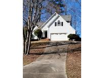 Charming two-story home featuring a symmetrical facade, attached garage, and well-maintained front yard with mature trees at 3503 Pine Grove Dr, Douglasville, GA 30135
