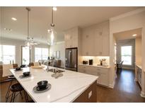 Bright kitchen boasts a large marble island, stainless steel appliances, and modern pendant lighting at 532 Pearl St, Cumming, GA 30040