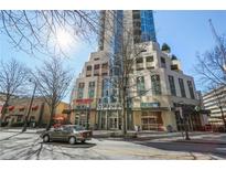 Modern building exterior showcasing architectural details, ground-level businesses, and a vibrant city street at 860 Peachtree Ne St # 2212, Atlanta, GA 30308