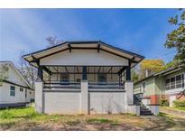 Charming home featuring a front porch with black trim, white siding, and a lovely landscaped yard at 1831 Jonesboro Se Rd, Atlanta, GA 30315