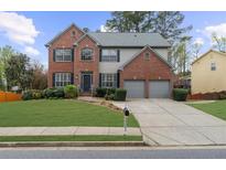 Beautiful two-story brick home with a well-manicured lawn and a two-car garage at 5280 Oak Hill Ter, Cumming, GA 30040