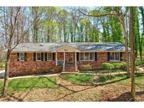Charming brick ranch home with a welcoming front porch and mature trees in a well-maintained yard at 730 Ponderosa Ct, Fayetteville, GA 30214