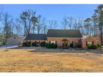 Charming single story home featuring brick facade, manicured landscaping, and mature trees at 35 Tracechain, Stockbridge, GA 30281