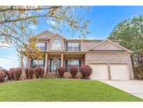 Charming two-story brick home with a manicured front lawn and attached two-car garage at 7847 Wrotham Cir, Atlanta, GA 30349