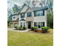 Charming two-story home features brick and white siding, black shutters, and well-maintained landscaping at 2412 Wingfield Dr, Austell, GA 30106
