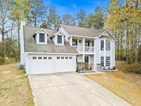 Charming two-story home featuring a two-car garage, inviting balcony, and manicured front yard at 2560 Ashley Downs Ln, South Fulton, GA 30349