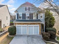 Charming two-story home featuring a stone-accented facade and attached two-car garage at 5965 Ellington Cv, Cumming, GA 30040