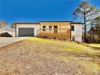 Charming single-level home featuring a front-facing garage, quaint porch, and inviting curb appeal on a sunny day at 2535 Impala Dr, Cumming, GA 30041