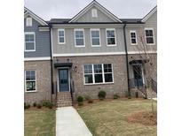 Charming townhome with gray brick, neutral siding, well maintained landscaping, and large windows at 1260 Ainsworth Aly # 47, Sugar Hill, GA 30518