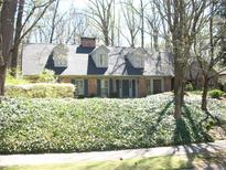 Charming brick home featuring dormer windows, a well-maintained lawn, and lush landscaping at 993 Castle Falls Dr. Ne Dr, Atlanta, GA 30329