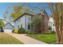 Charming home featuring a brick facade, blue siding, mature trees, and a well-manicured lawn at 108 Kirk Crossing Dr, Decatur, GA 30030