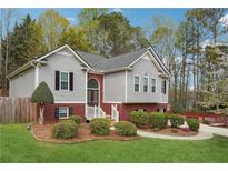 Charming home with gray siding, red brick accents, and a beautifully landscaped front yard at 21 Enclave Walk, Powder Springs, GA 30127