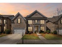 Charming two-story brick home with attached garage and well-manicured lawn at dusk at 11620 Crestview Ter, Johns Creek, GA 30024